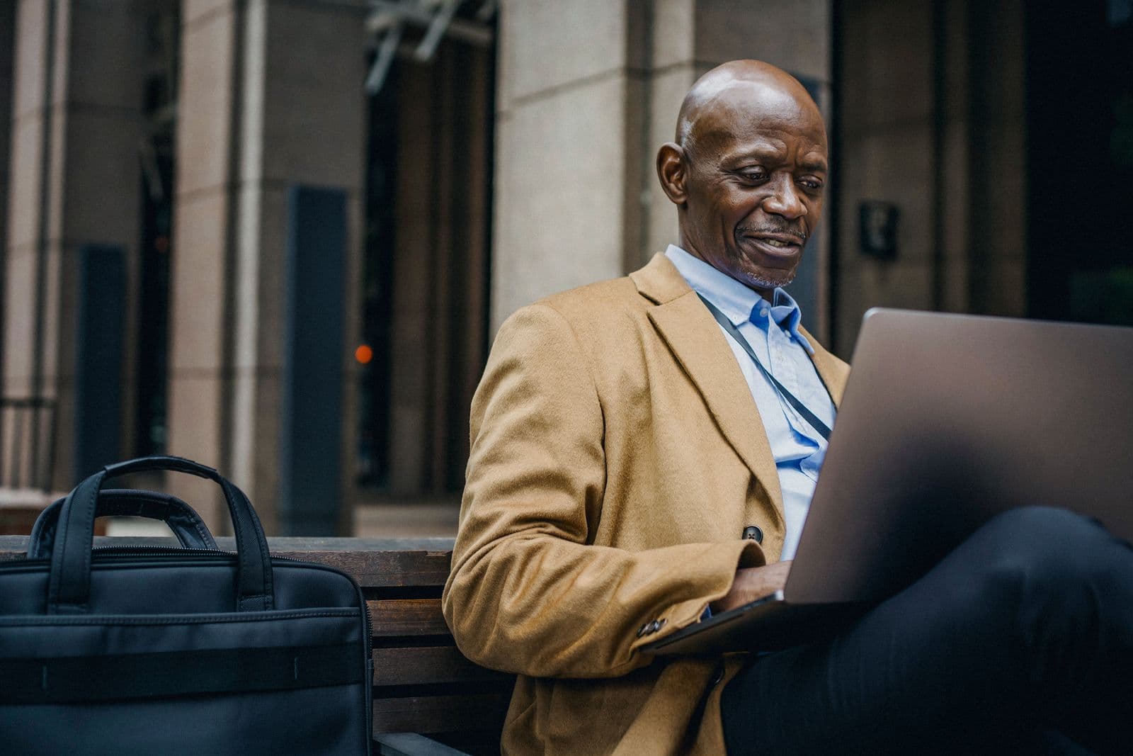 A businessman reviewing performance data on his laptop outdoors in the city