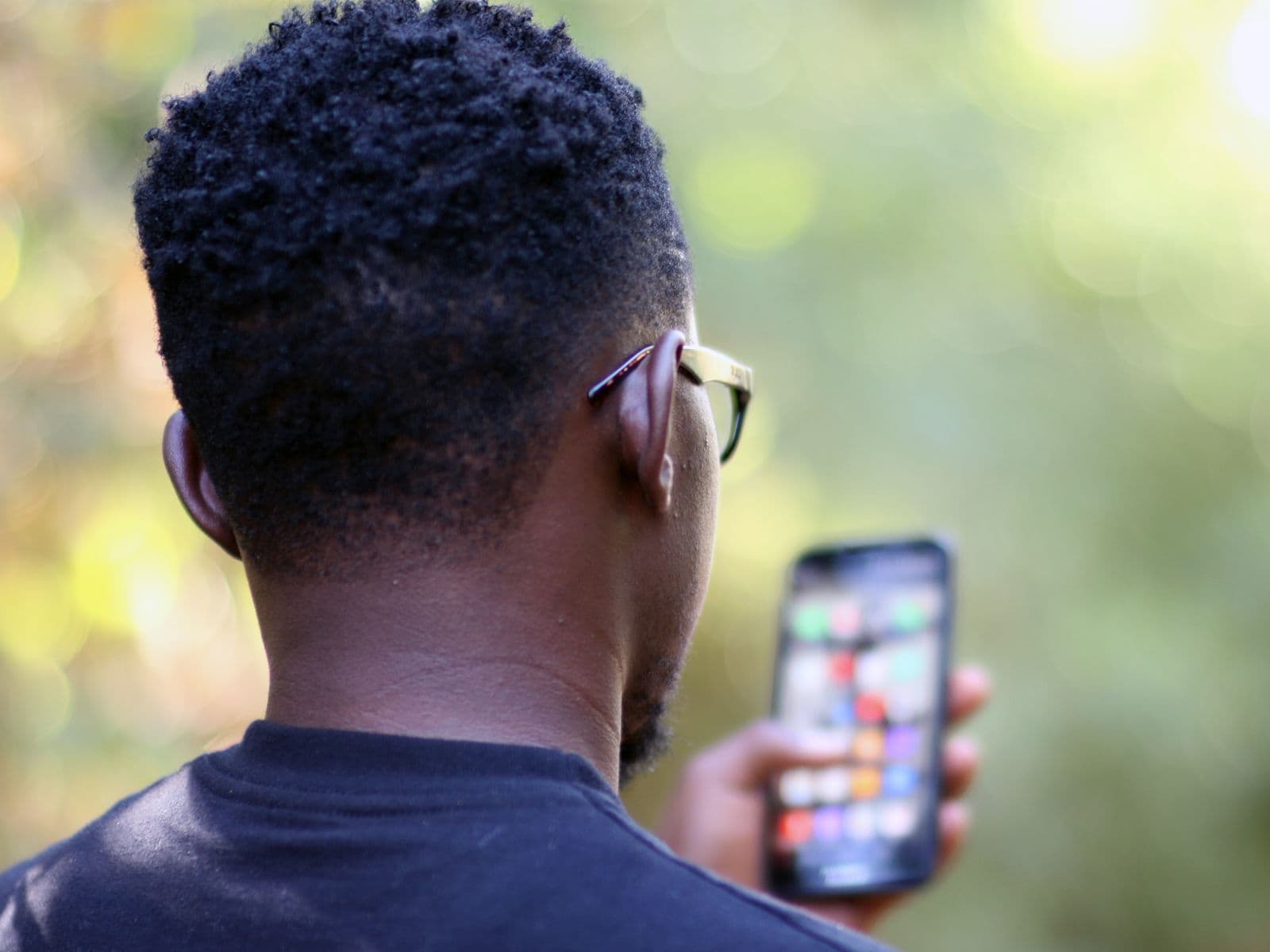 A man outdoors in Kenya checking his phone — mobile money on the go